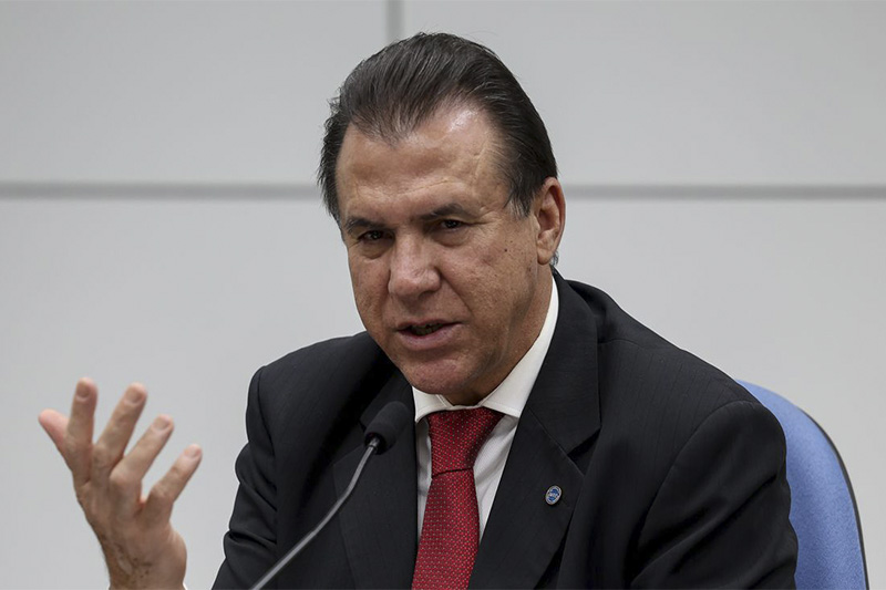 Gráfico da taxa Selic em alta com prédio do Ministério da Fazenda em Brasília ao fundo