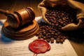 Gavel de madeira sobre grãos de café com documentos jurídicos ao fundo