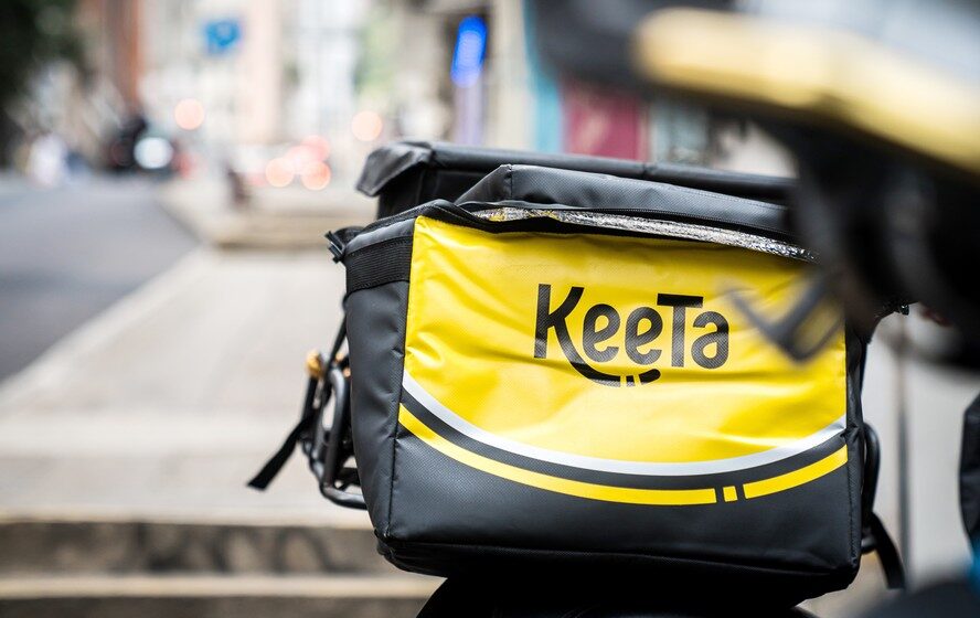 Logotipo Keeta sobre mapa de São Paulo com ícones de delivery e cifra de R$ 1 bilhão