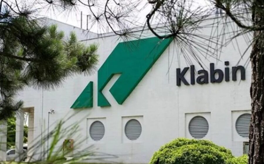 Gráfico de ações KLBN11 em queda com ícone de custo industrial em destaque