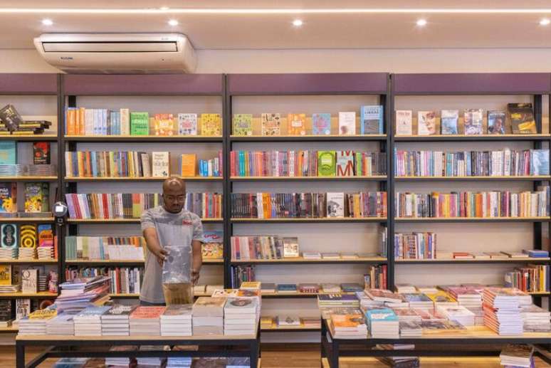Fachada de livraria independente com banner "Quem lê vota pelo Brasil" e livros expostos na vitrine