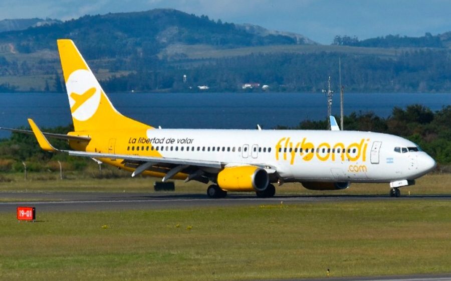 Avião da Flybondi no aeroporto com texto sobre saída do Brasil e apenas três low costs restantes