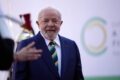 Lula discursa com logotipos da Meta ao fundo, simbolizando confronto entre governo brasileiro e big techs