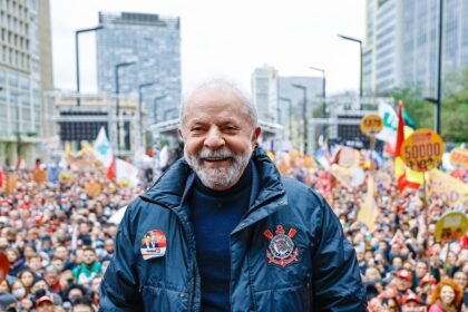 Lula observando celular com mobilização digital de pais de crianças com câncer nas ruas