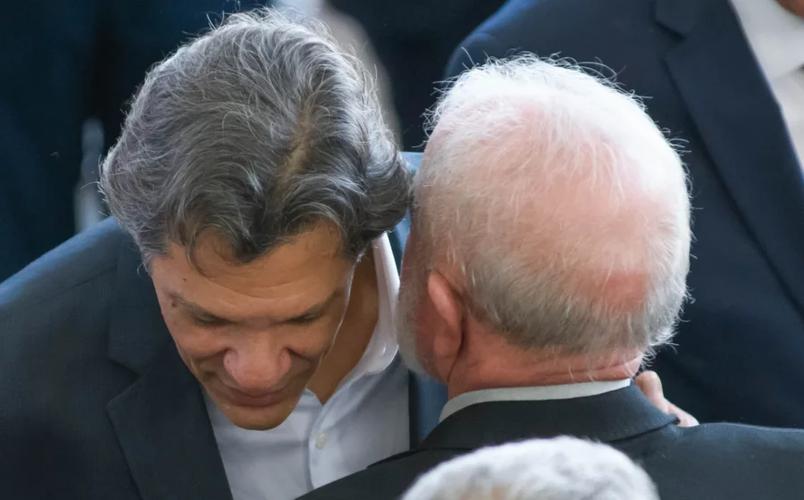 Lula pensativo com gráficos de alta do dólar e cadeira vazia do Ministério da Fazenda ao fundo