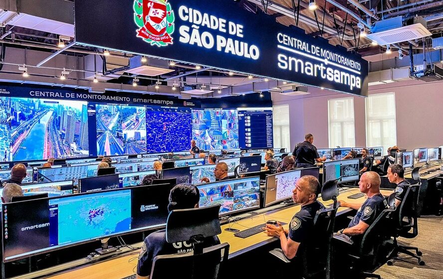 Sala de monitoramento do SmartSampa com múltiplas telas exibindo câmeras de vigilância urbana em São Paulo