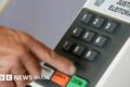 Ilustração de trabalhador denunciando assédio eleitoral no canal do MTE com ícone de balança e smartphone