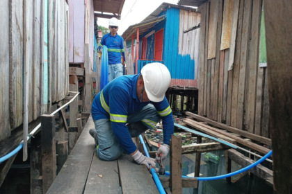 Palafitas em Manaus com tubulações de água tratada ancoradas nas passarelas de madeira sobre o rio Negro
