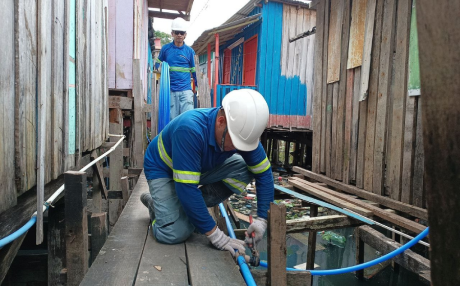 Palafitas em Manaus com tubulações de água tratada ancoradas nas passarelas de madeira sobre o rio Negro