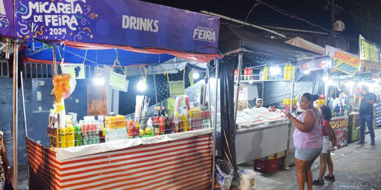 Ambulantes trabalhando na Micareta de Feira de Santana com barraquas coloridas e multidão