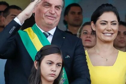 Print de publicação de Michelle Bolsonaro com frase "DEUS É O DONO DO BRASIL" em letras maiúsculas sobre fundo escuro