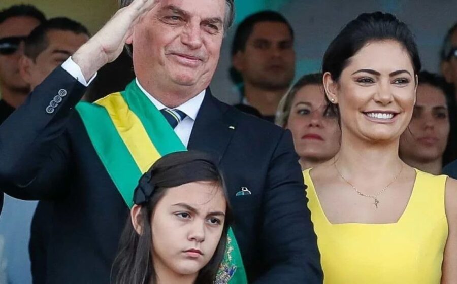 Print de publicação de Michelle Bolsonaro com frase "DEUS É O DONO DO BRASIL" em letras maiúsculas sobre fundo escuro