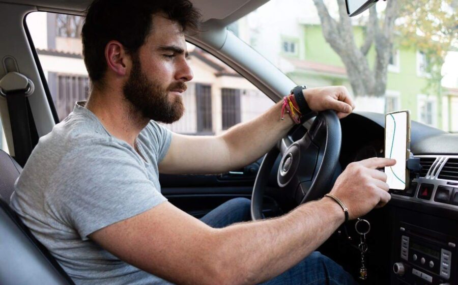 Motorista de aplicativo dirigindo carro à noite, simbolizando vulnerabilidade e insegurança no trabalho