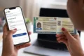 Smartphone exibindo aplicativo da Carteira de Identidade Nacional com documento sendo entregue por carteiro