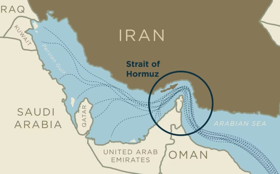 Navio cargueiro no Estreito de Ormuz com costa iraniana ao fundo, simbolizando bloqueio que encarece alimentos