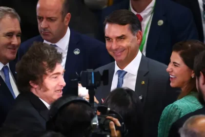 Tesoura cortando documento orçamentário com bandeira do Brasil ao fundo, simbolizando corte de gastos públicos