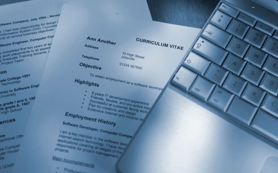 Currículo impresso cortado ao meio com frase "Contrate-me para desbloquear todo o meu potencial" em fundo branco