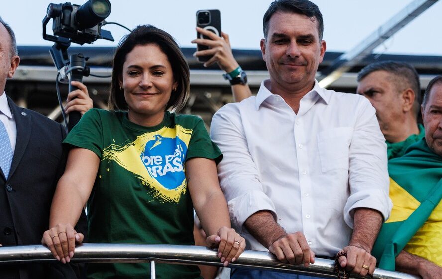 Michelle e Jair Bolsonaro no sofá, tornozeleira eletrônica visível no tornozelo do ex-presidente