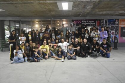 Estudantes de jogos digitais da Baixada Santista olhando para o horizonte com laptops, simbolizando êxodo de talentos