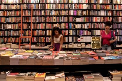 Fachada de livraria independente com cartaz "Quem lê vota pelo Brasil" na vitrine