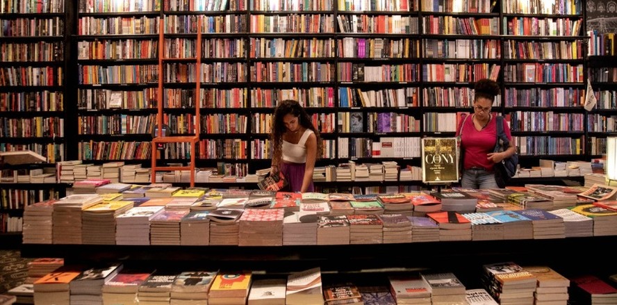 Fachada de livraria independente com cartaz "Quem lê vota pelo Brasil" na vitrine