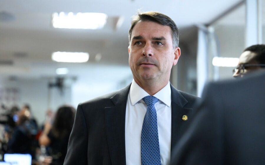 Senador Flávio Bolsonaro em retrato oficial, simbolizando investigações sobre alianças políticas, milícias e apostas online