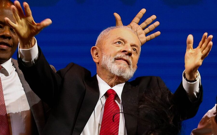 Lula em discurso no Planalto com gráfico de queda da B3 e alta do dólar ao fundo