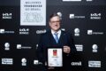 Troféu do Prêmio Melhores Franquias 2026 com logos Divino Fogão e Kumon destaque