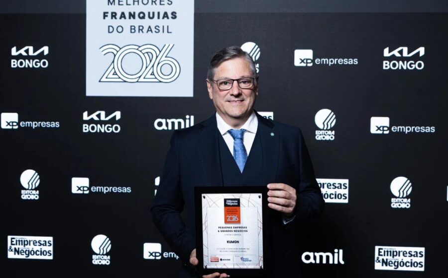 Troféu do Prêmio Melhores Franquias 2026 com logos Divino Fogão e Kumon destaque