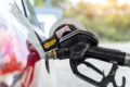 Bomba de diesel vermelho em posto com caminhão abastecendo, símbolo da nova ordem executiva de Trump