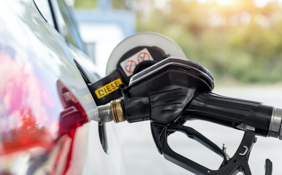 Bomba de diesel vermelho em posto com caminhão abastecendo, símbolo da nova ordem executiva de Trump