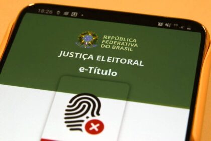 Rosana Magalhães criadora do e-Título segurando smartphone com aplicativo aberto
