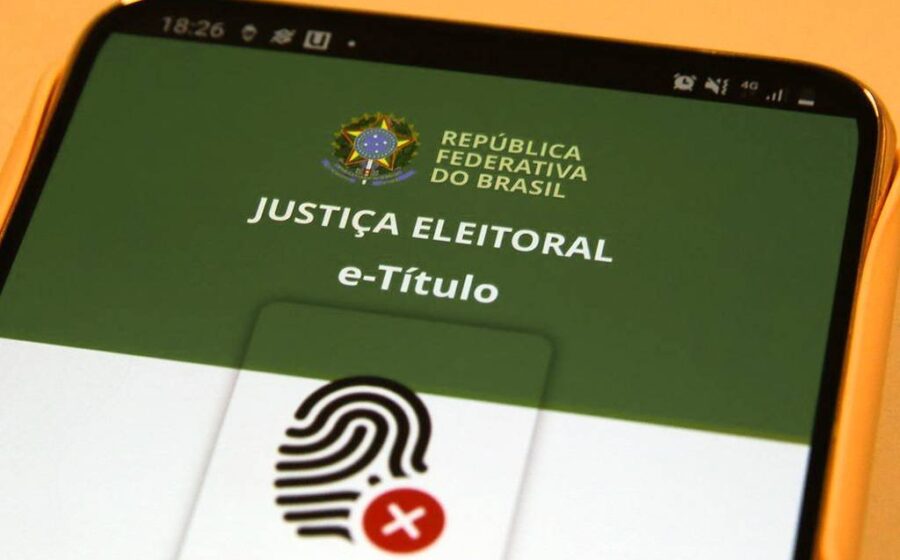 Rosana Magalhães criadora do e-Título segurando smartphone com aplicativo aberto