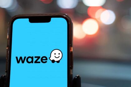 Uri Levine, cofundador do Waze, sorri em evento no Brasil com fundo dourado simbolizando oportunidade