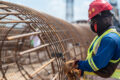 Trabalhadores da construção civil em canteiro de obras com gráficos de emprego e atividade