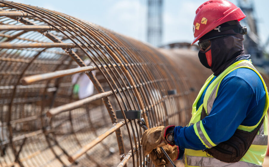 Trabalhadores da construção civil em canteiro de obras com gráficos de emprego e atividade