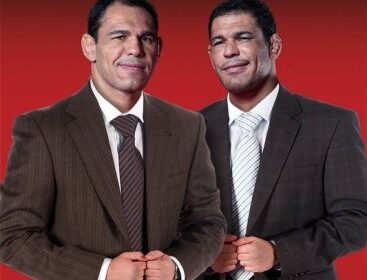 Irmãos Nogueira, Minotauro e Minotouro, em pose de negócios diante de unidade da franquia Team Nogueira