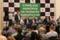 Município brasileiro com parques eólicos e solares ao fundo, simbolizando transição energética local