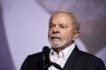 Lula discursa com gráficos de dívida pública e juros ao fundo, símbolo de desafio fiscal