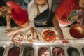 Prato meio comido em mesa de restaurante com medicamento GLP-1 ao lado