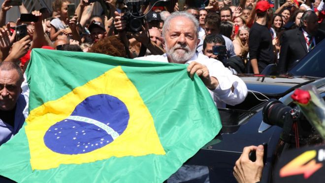 Lula e Flávio Bolsonaro em destaque com símbolo do TSE e documentos de quebra de sigilo