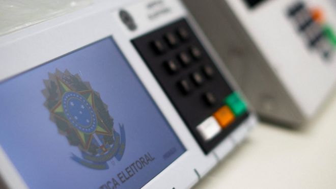 Ministro do TSE segurando logo do WhatsApp com símbolo de proibição e texto "200 mil inscritos"