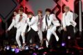 BTS no palco do Estádio Morumbis em São Paulo com multidão de fãs iluminando a plateia com lightsticks