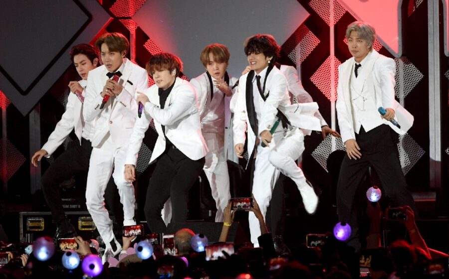 BTS no palco do Estádio Morumbis em São Paulo com multidão de fãs iluminando a plateia com lightsticks