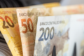 Gráfico de alta de juros da dívida francesa com bandeira do Brasil ao fundo, simbolizando risco fiscal