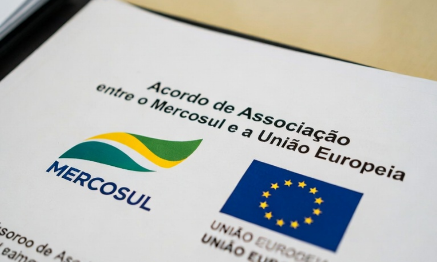 Eleitores diversos unidos diante de urna eletrônica com bandeira do Brasil ao fundo