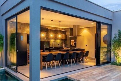 Área gourmet integrada à sala com bancada, cozinha e varanda em fluxo contínuo