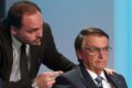 Carlos Bolsonaro em bastidores de debate na TV Globo, expressão séria