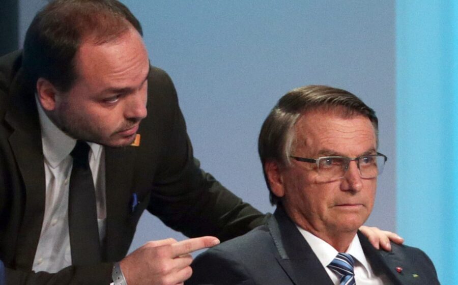 Carlos Bolsonaro em bastidores de debate na TV Globo, expressão séria