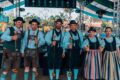 Multidão celebrando Oktoberfest gratuita no Novo Mercadão de Ribeirão Preto com chope artesanal e joelho de porco